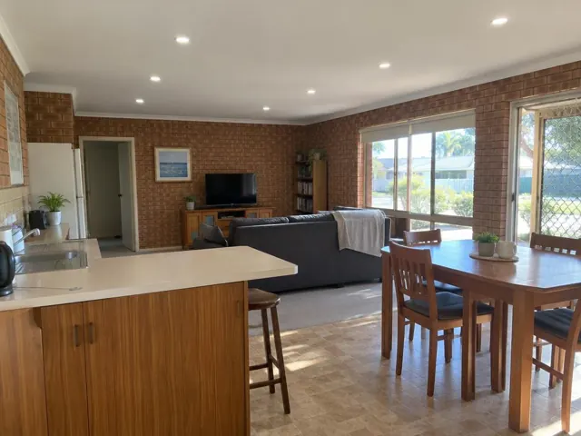 Living and dining room with flush LED downlights in a brick home interior in Budgewoi